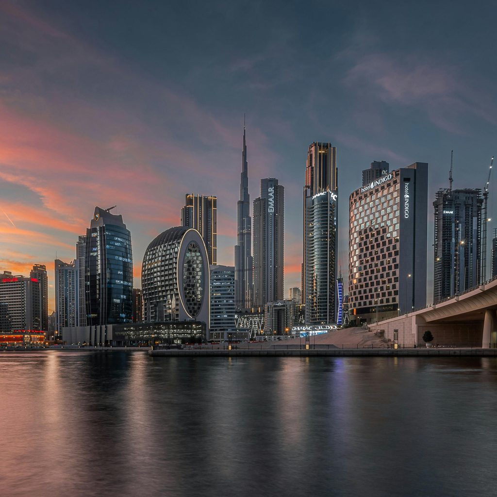 Wooden boats sailing across the peaceful Dubai Creek at sunset.