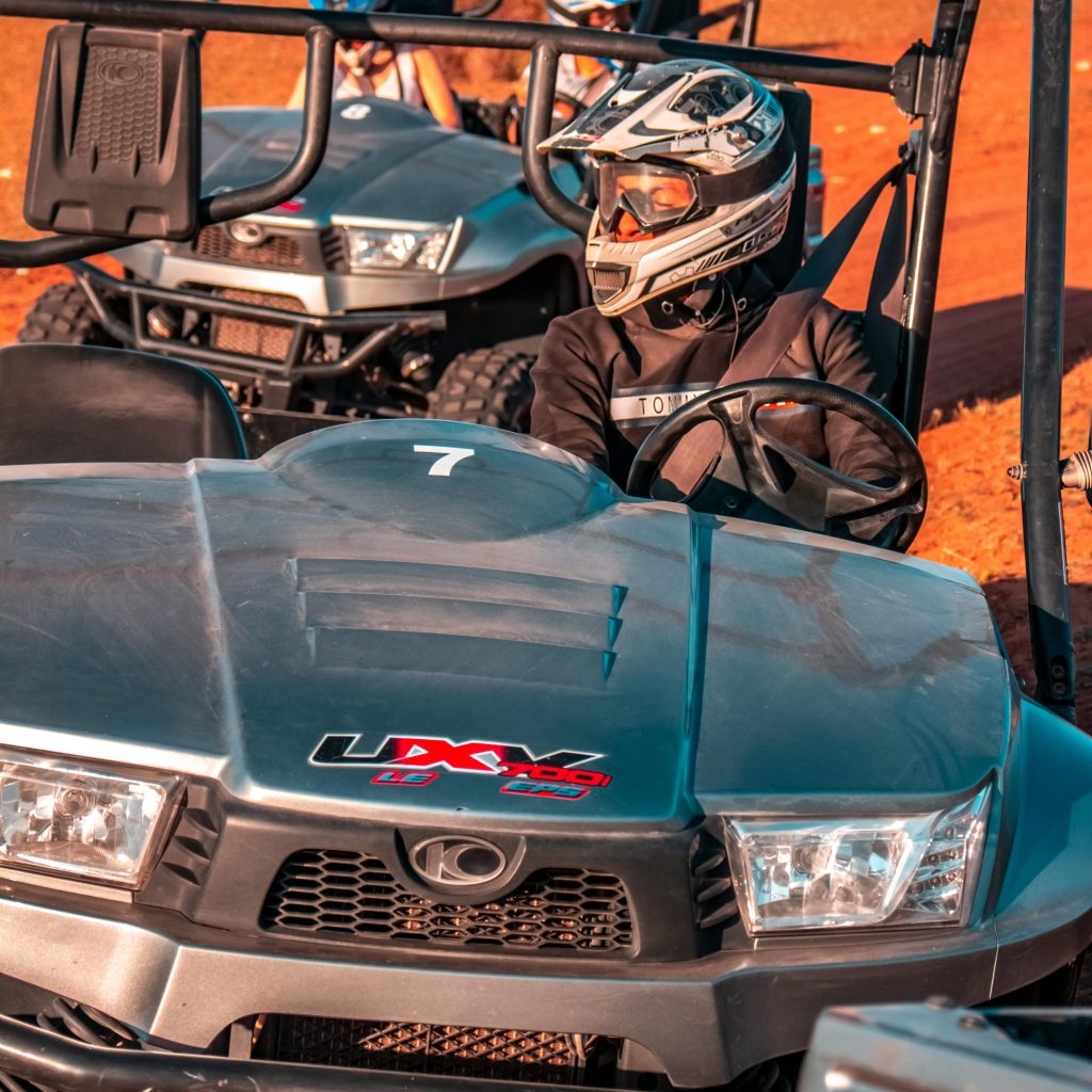 Tourists riding dune buggies over Dubai’s golden desert dunes – a budget travel tip Dubai for affordable adrenaline-packed adventures.