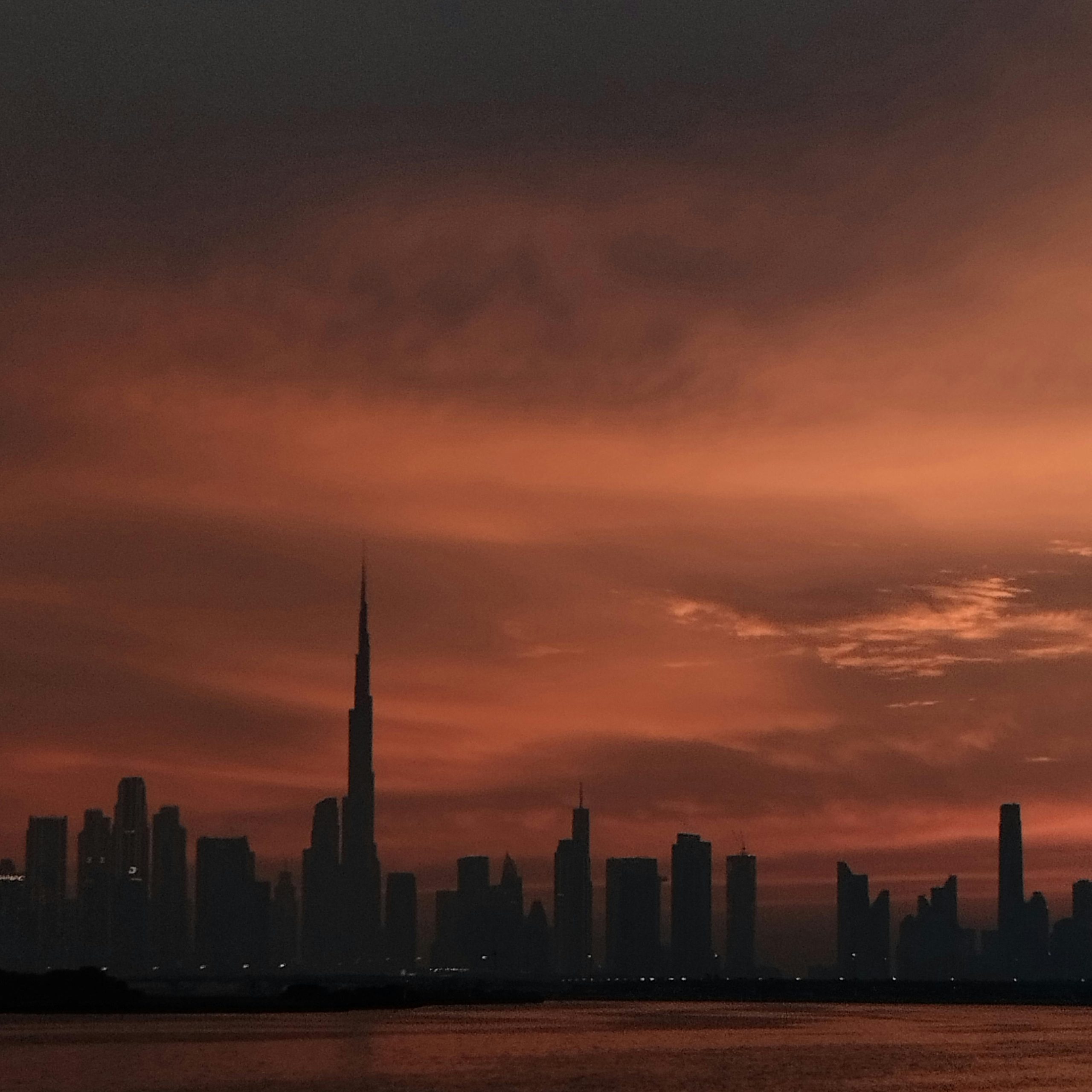 Backpackers exploring Dubai’s iconic Burj Khalifa and metro with maps in hand – budget travel tips Dubai for affordable adventures in the city of gold.